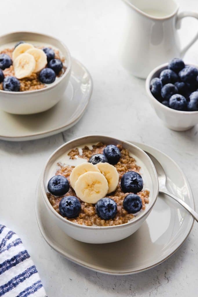 Steel cut oatmeal in a bowl with bananas and blueberries.