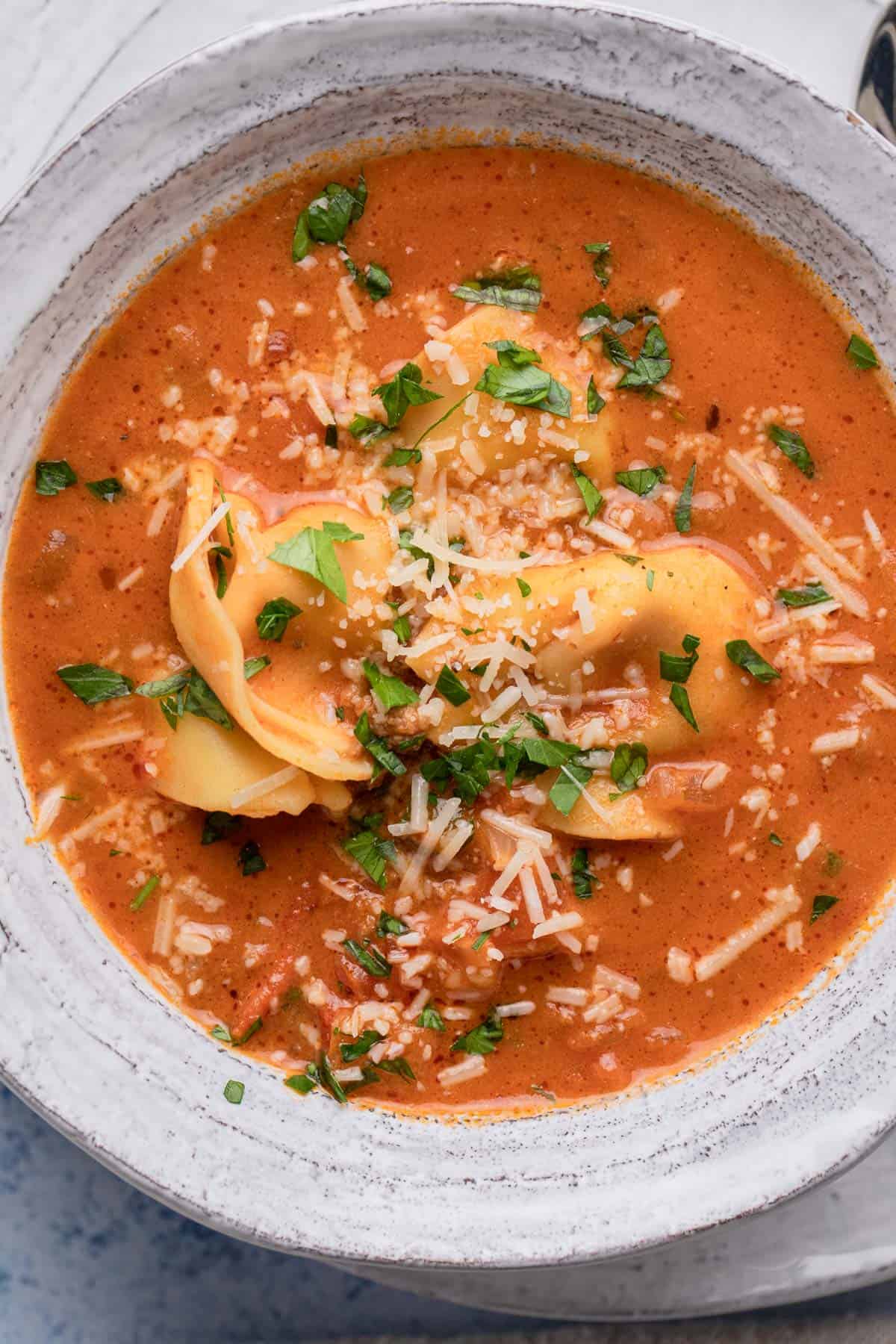 A bowl of tomato tortellini soup.