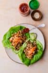 lettuce wraps on a plate with chili garlic sauce on the side
