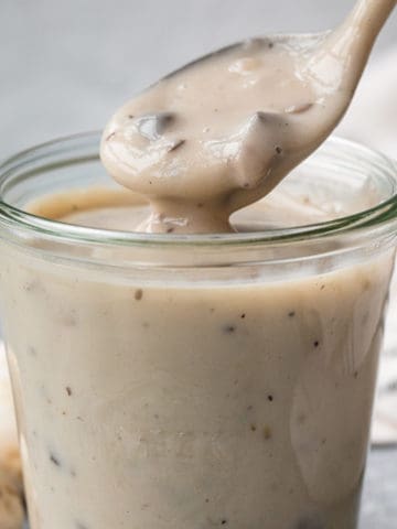 cream of mushroom soup on a spoon over a container