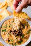 velveeta queso in a bowl with a chip dipping into it