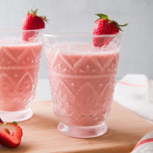 2 glasses filled with a pink strawberry oatmeal smoothie