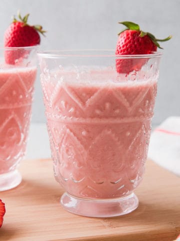 2 glasses filled with a pink strawberry oatmeal smoothie