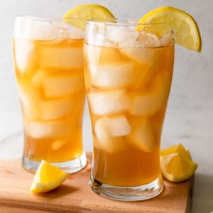 two glasses of iced tea lemonade with lemon wedges