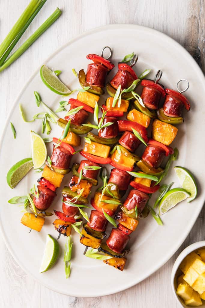 a platter of kabobs with green onions scattered