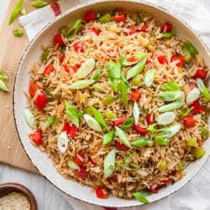 singapore fried rice in bowls with green onion garnishes