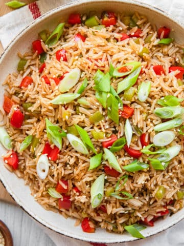singapore fried rice in bowls with green onion garnishes