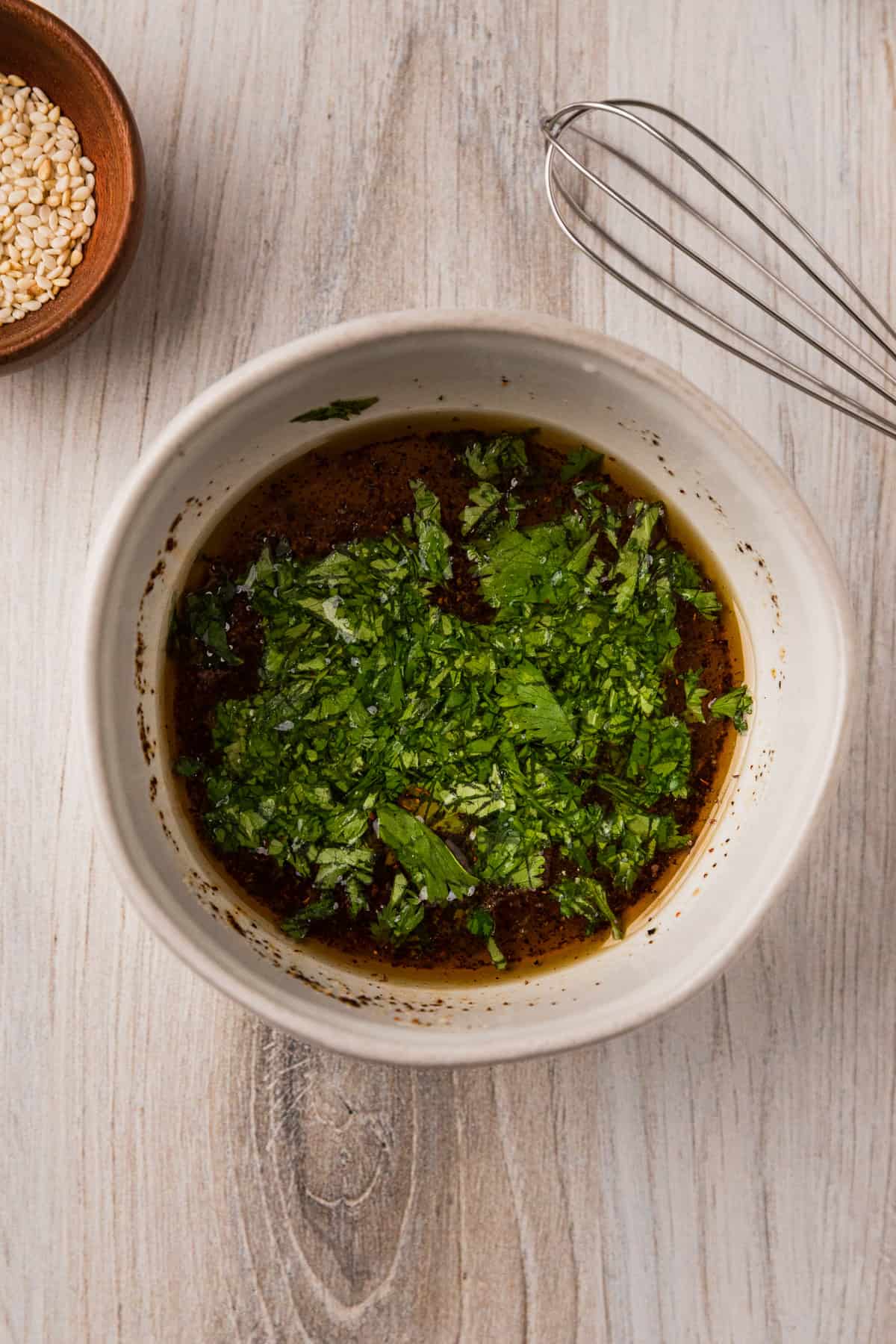 a bowl of vinaigrette with chopped cilantro.