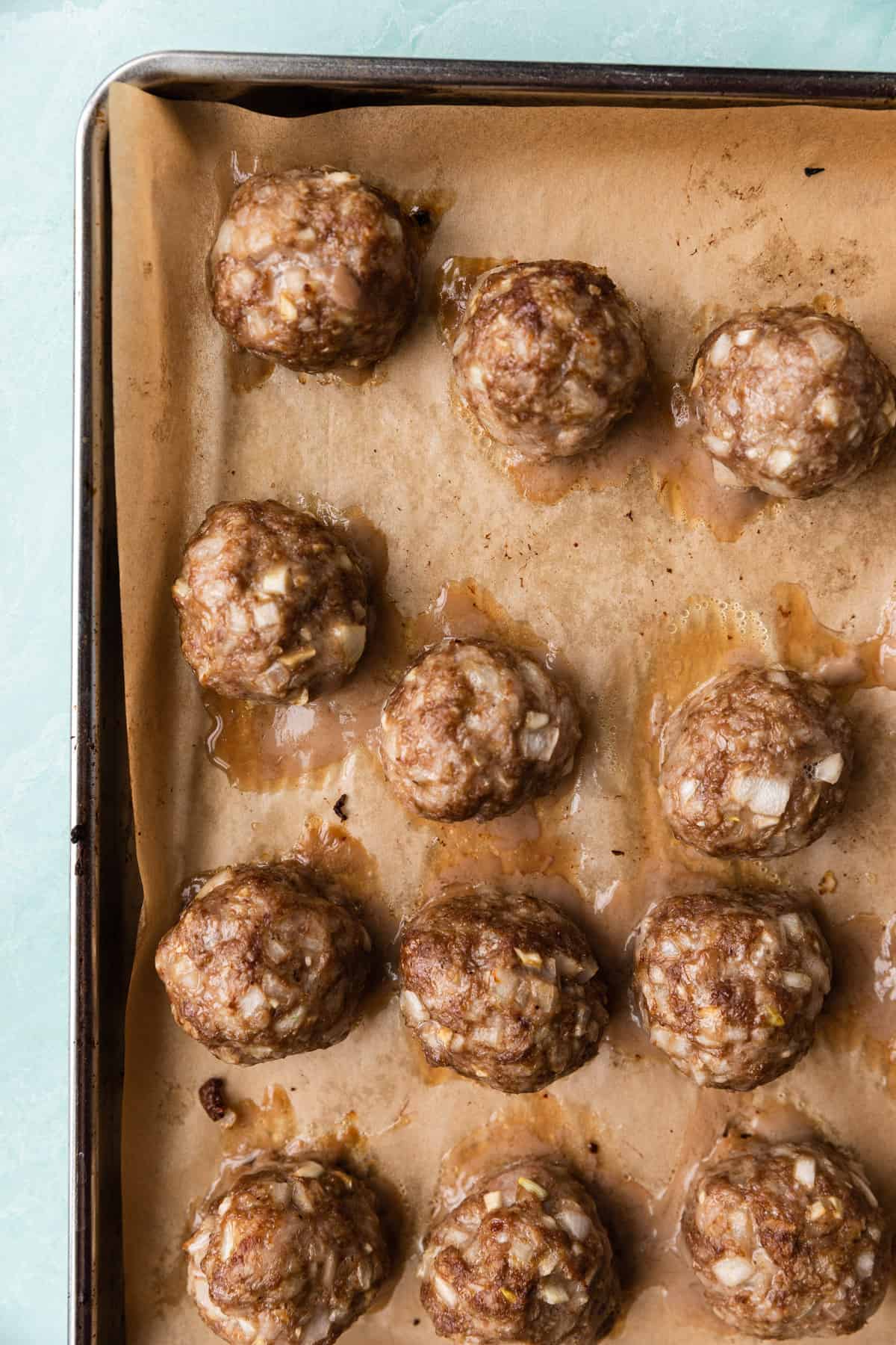 Cooked meatballs on a baking sheet.