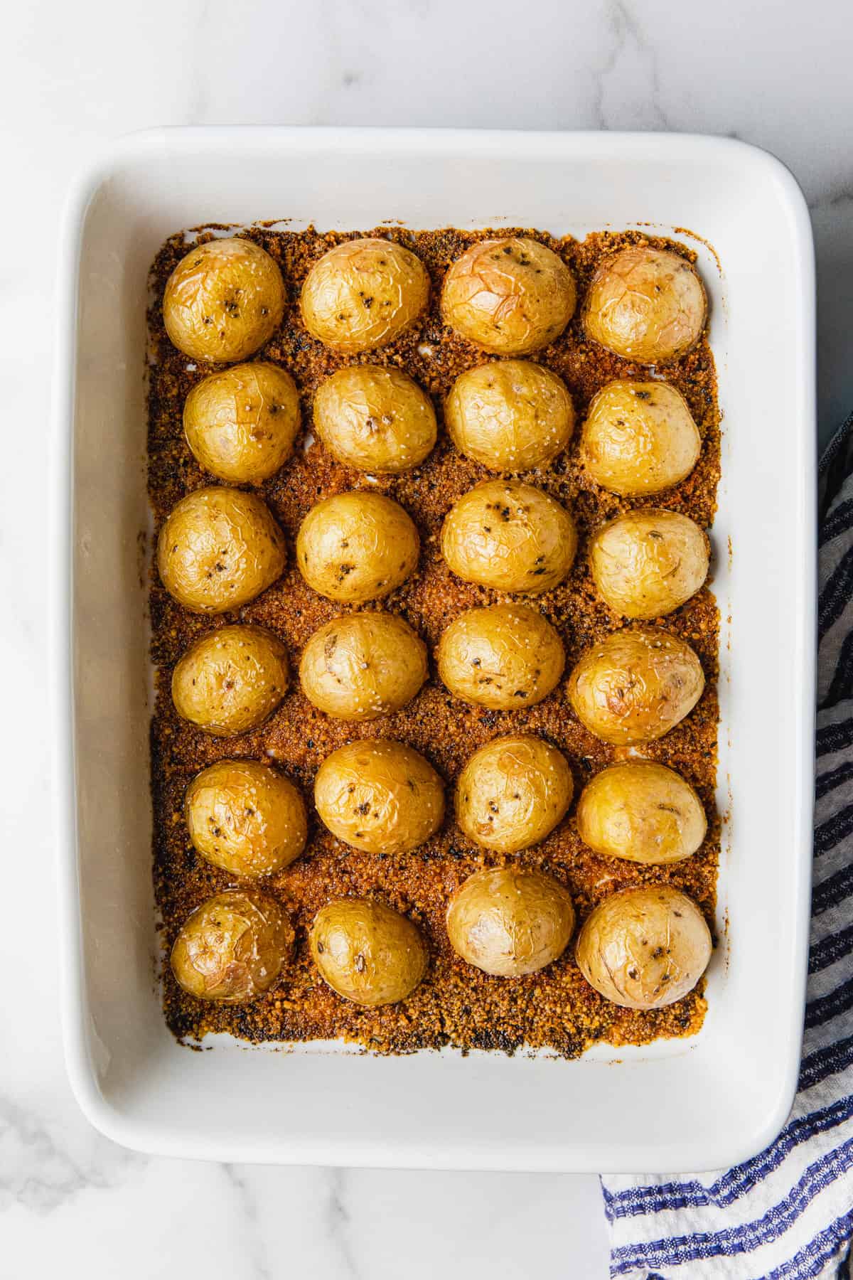 Potatoes cut side down in a baking dish before and after baking.
