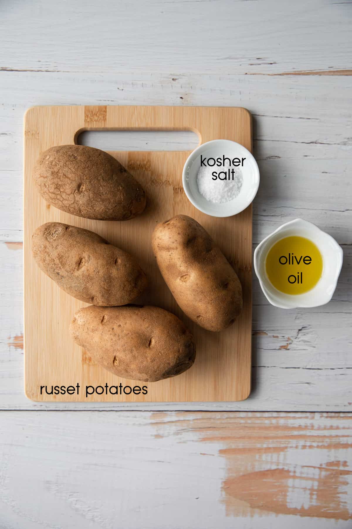 potatoes, salt and melted butter on a white wooden background