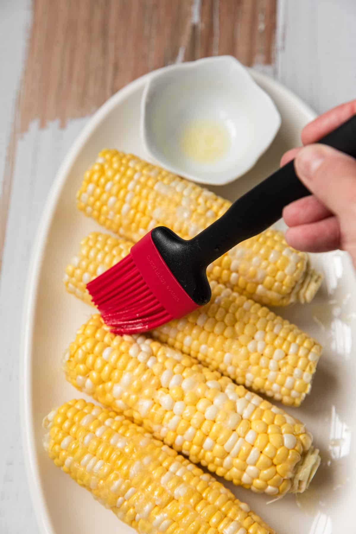 brushing corn with melted butter