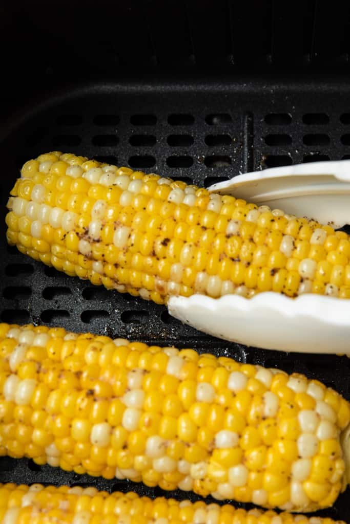 turning corn over with tongs