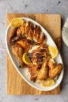 a platter of cooked chicken with lemons