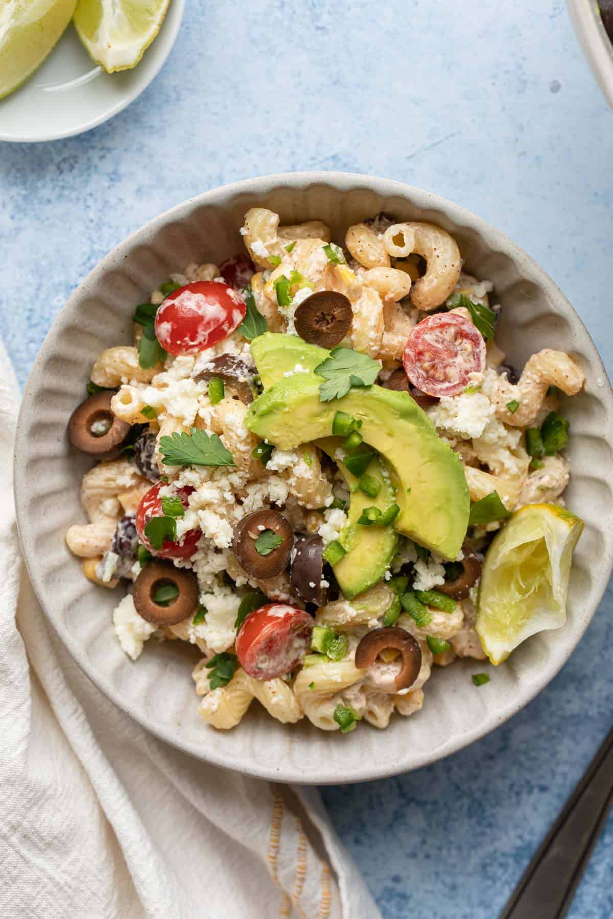 a bowl of pasta salad on a blue background