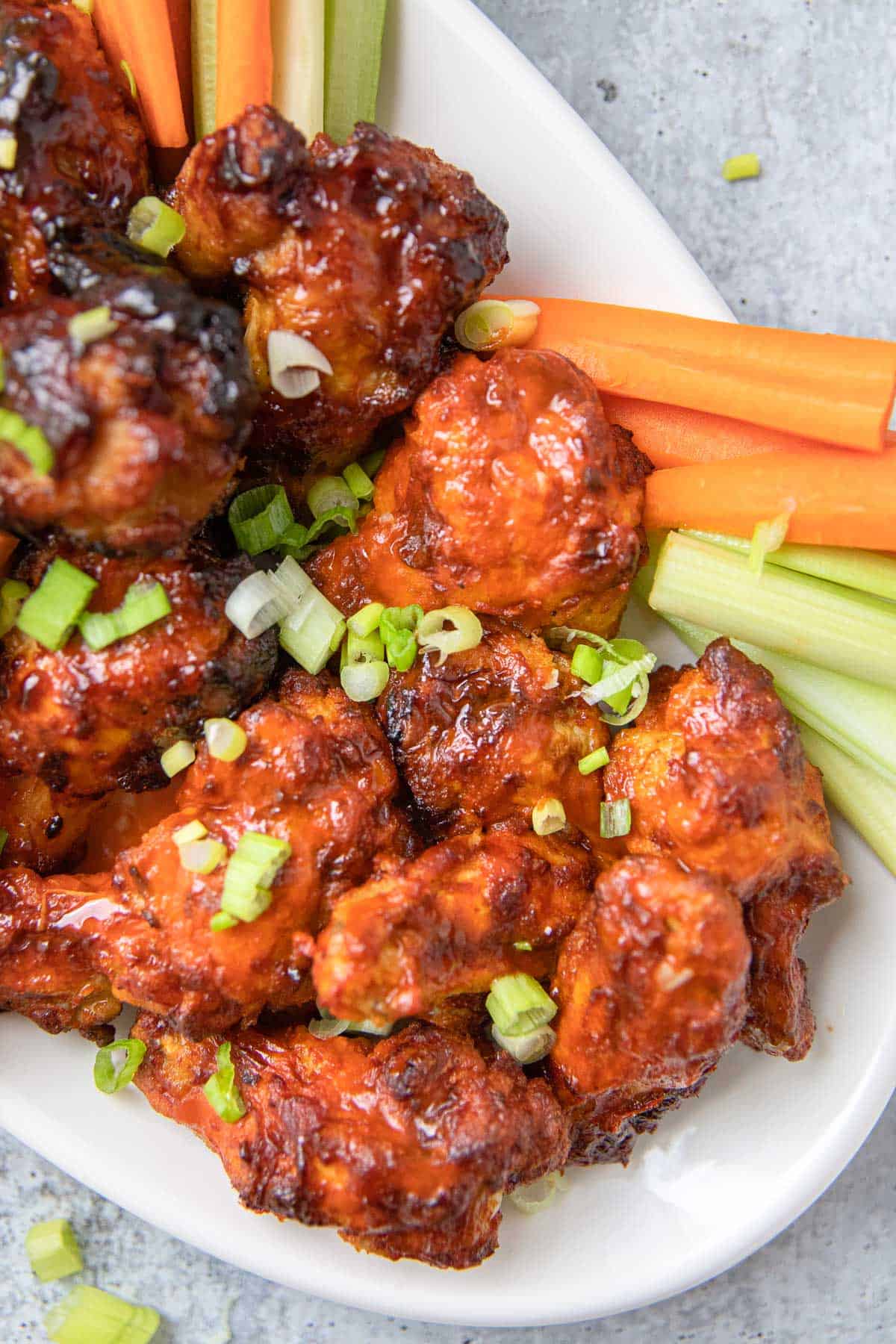 a platter with wings and sliced carrots, celery