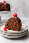 a piece of cake topped with a cherry