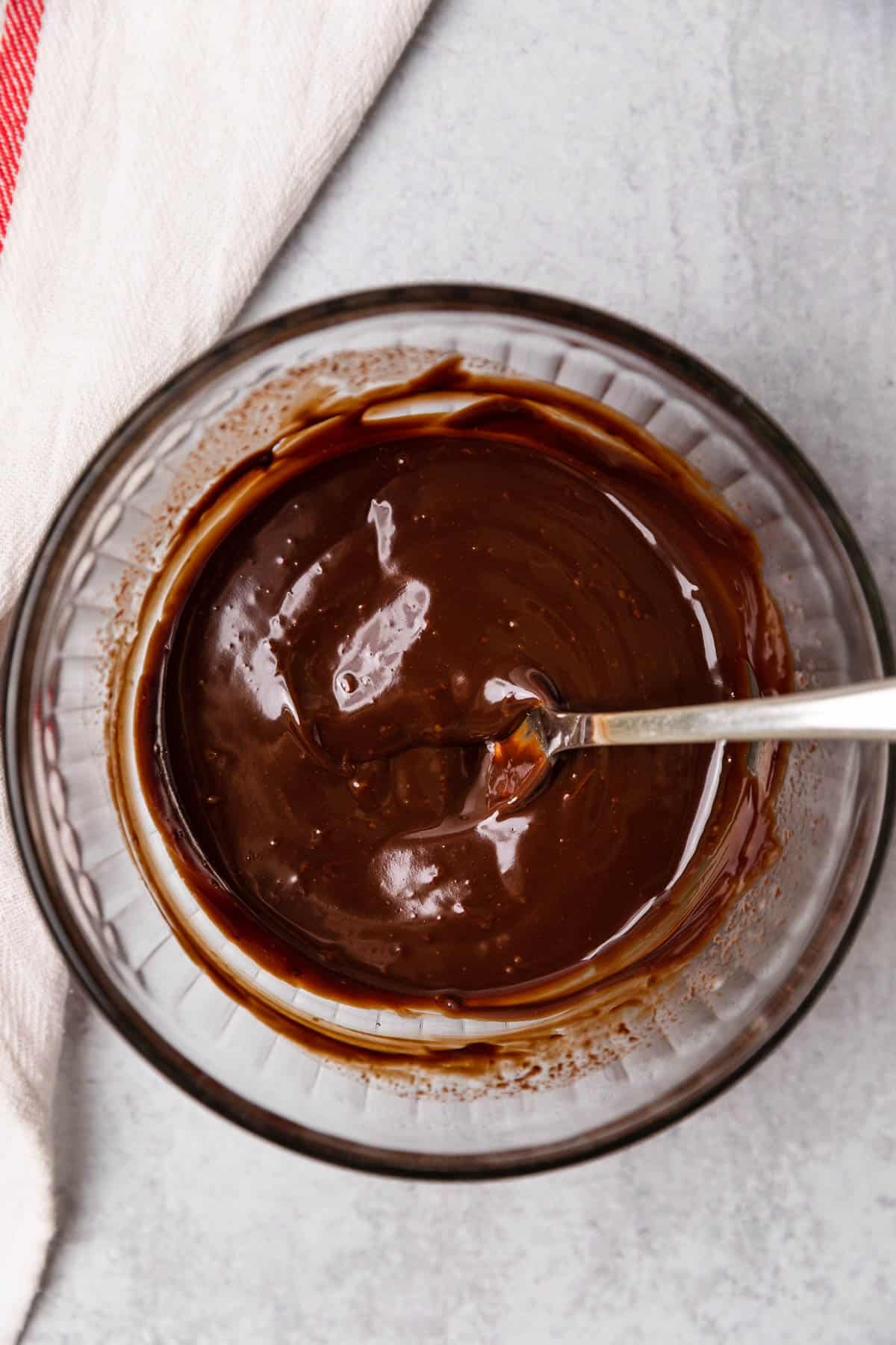 chocolate glaze in a small bowl with a spoon