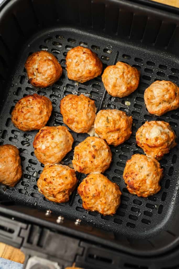 cooked meatballs in an air fryer basket