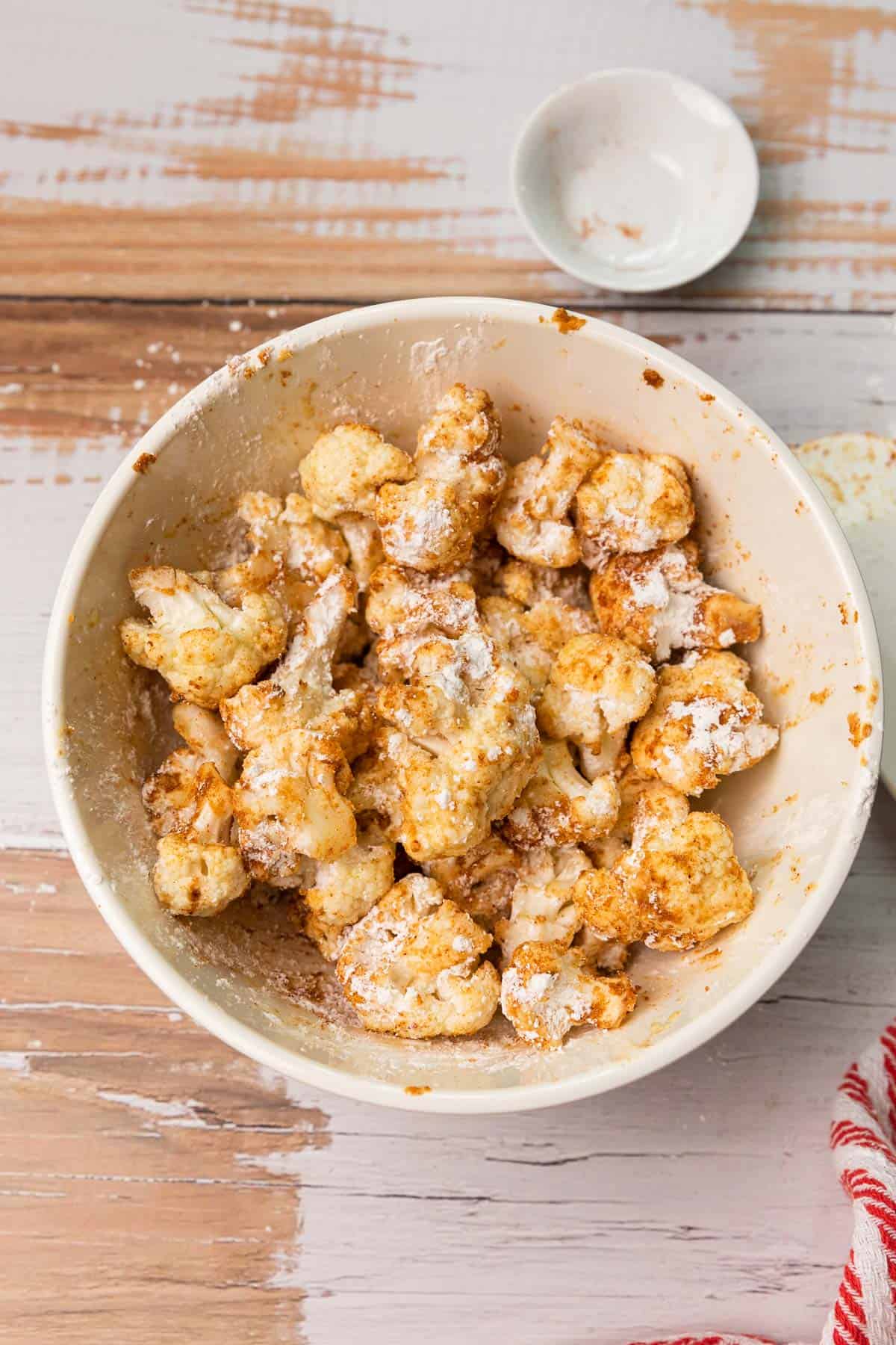 cauliflower florets with seasoning and cornstarch sprinkled over