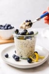 a spoonful of oatmeal and blueberries from a glass jar