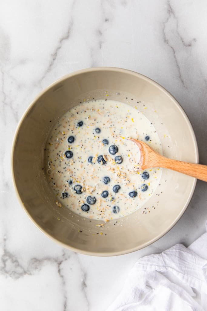 mixing blueberries in a oatmeal mixture