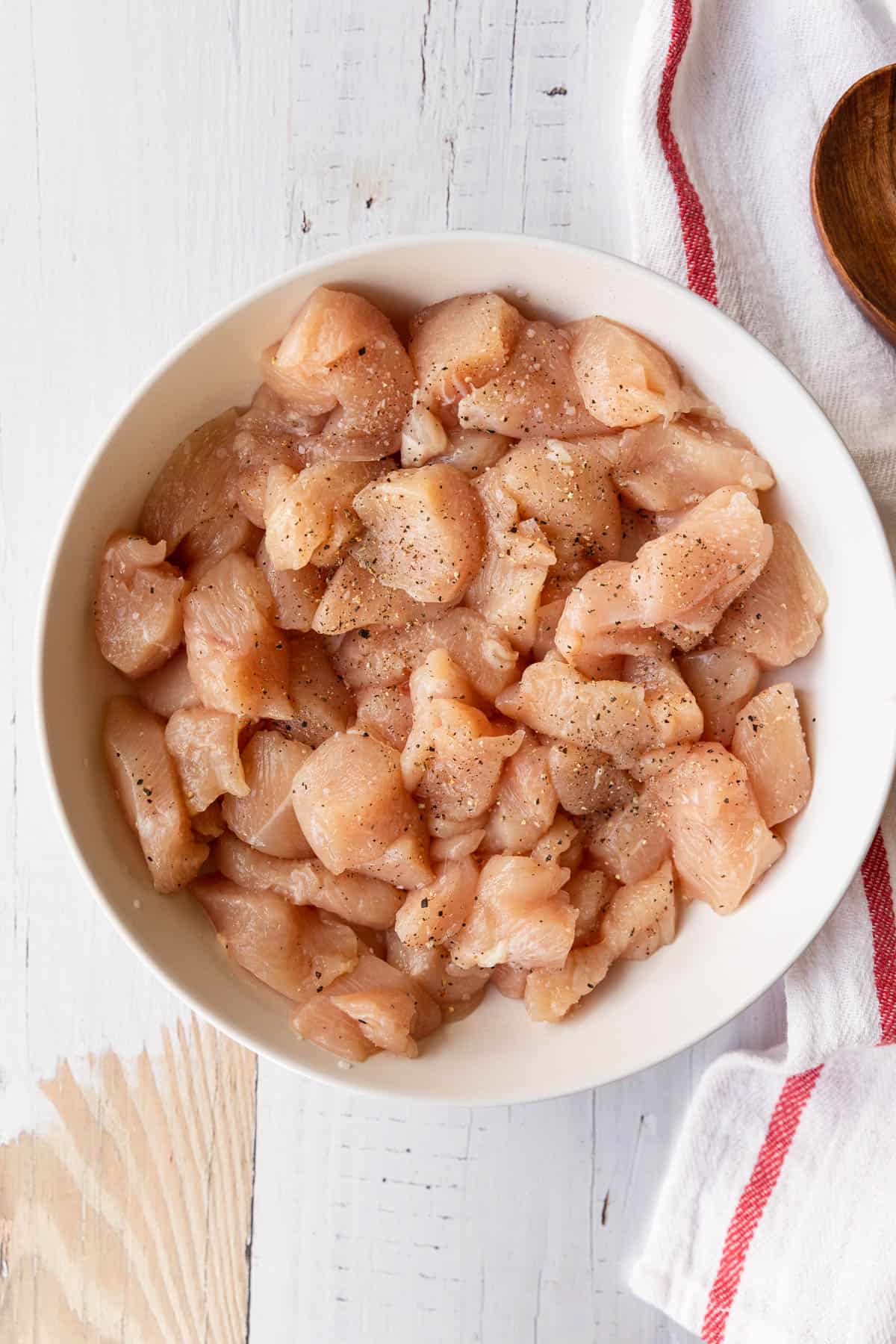 a bowl of raw chicken breast cut into small pieces