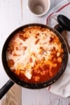 a skillet with chicken, tomato sauce and cream