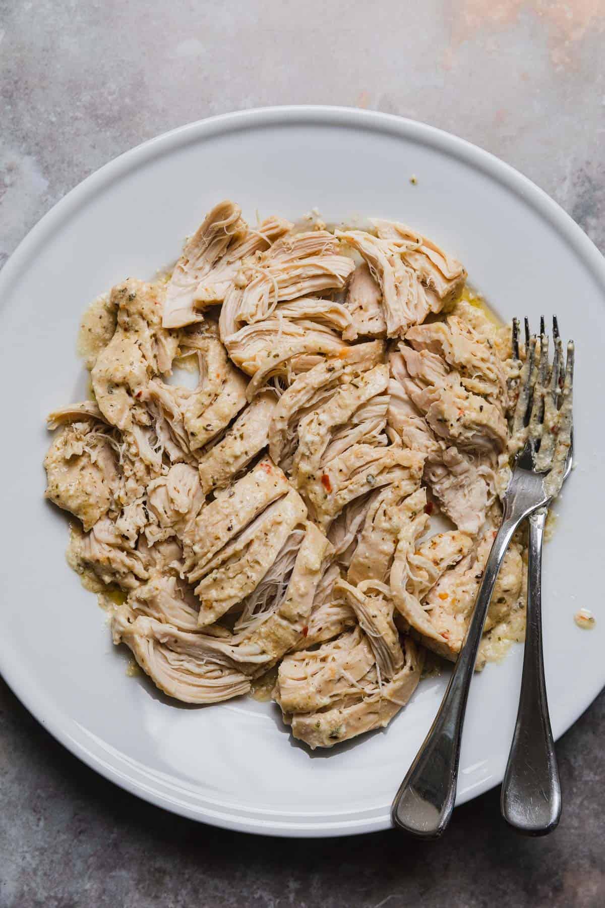 shredded cooked chicken on a plate with two forks