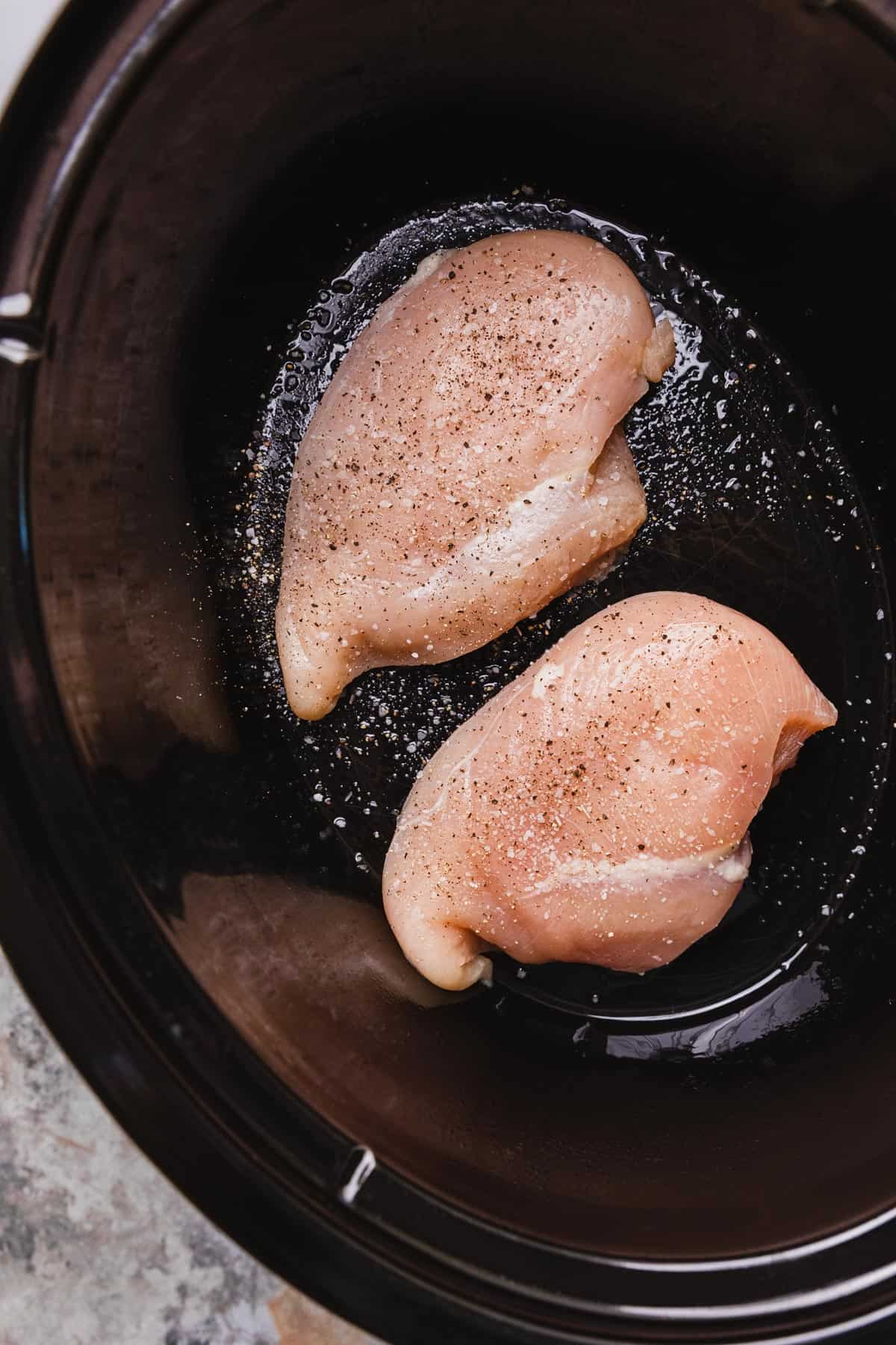 uncooked chicken breasts in a crockpot