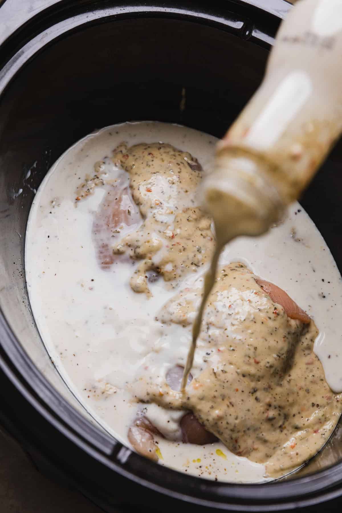 milk being poured over uncooked chicken