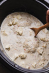stirring sauce over chicken