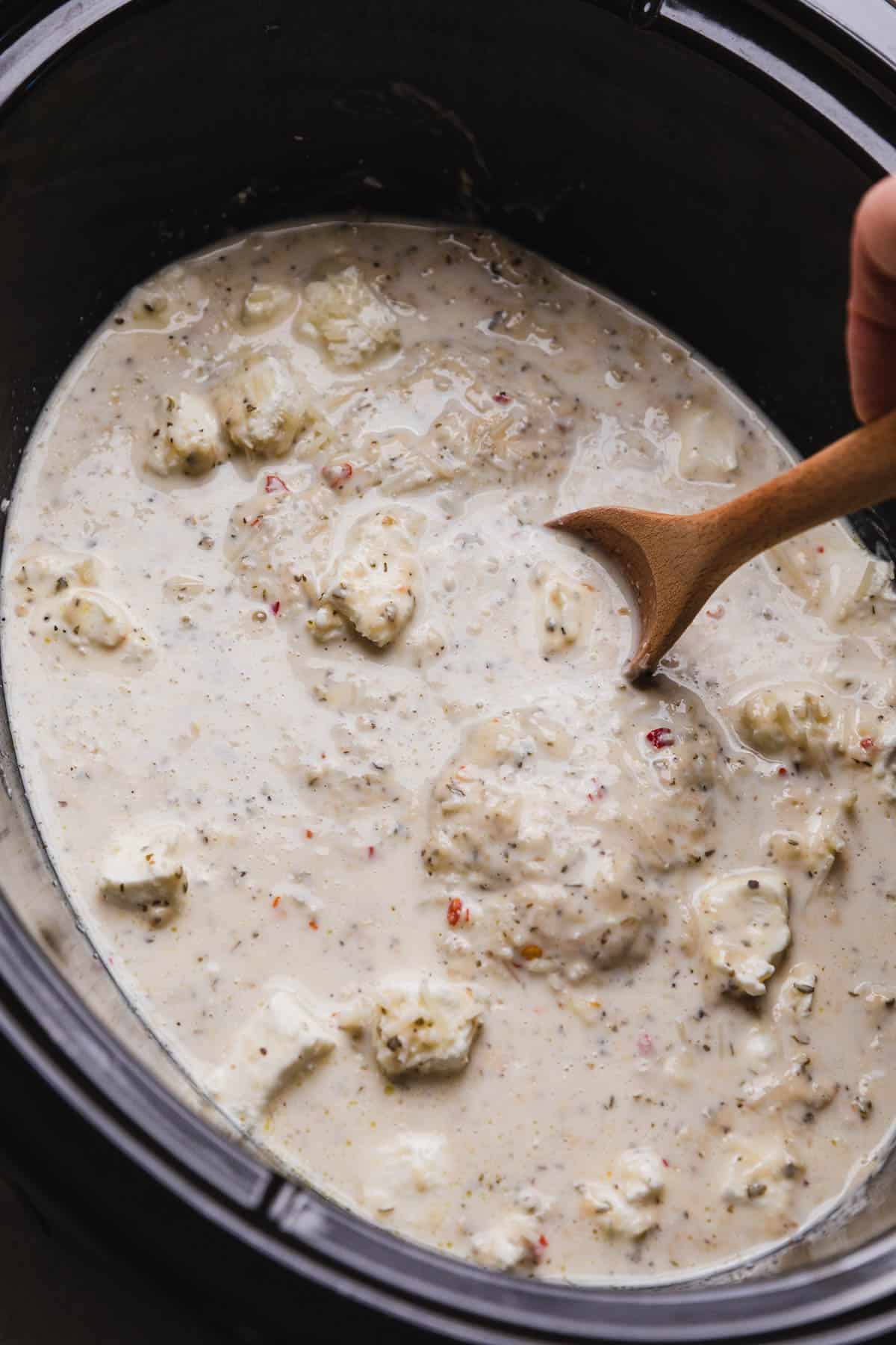 stirring sauce over chicken