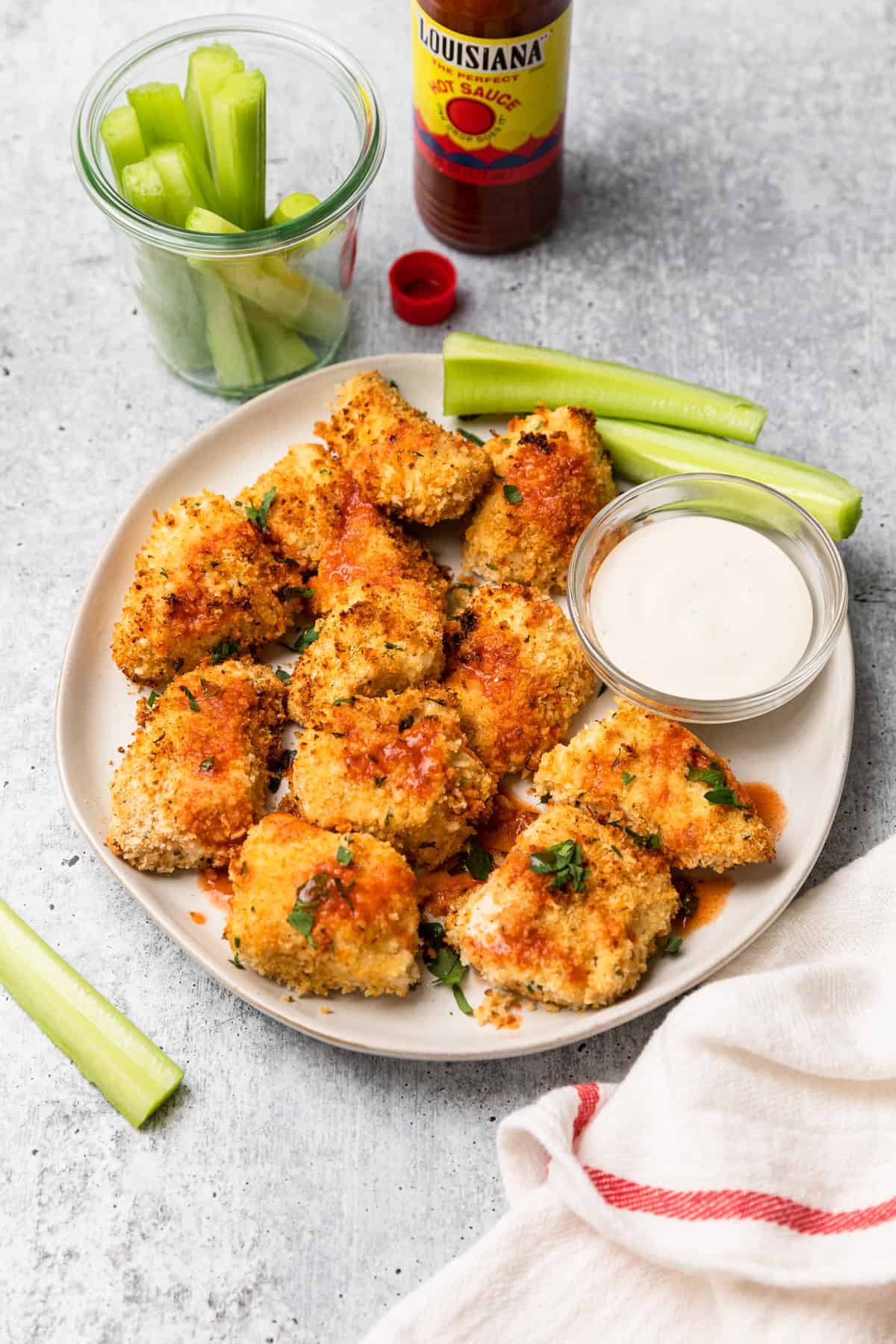 a plate of chicken bites with some hot sauce dabbed on