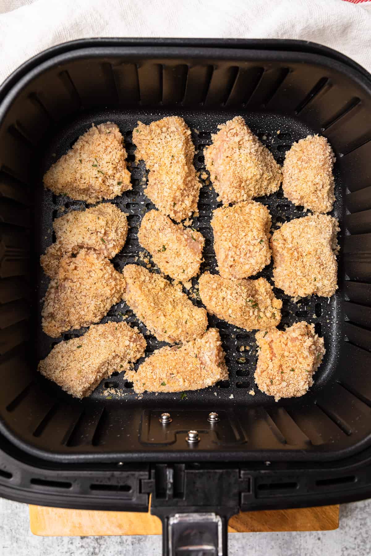 chicken pieces in an air fryer basket