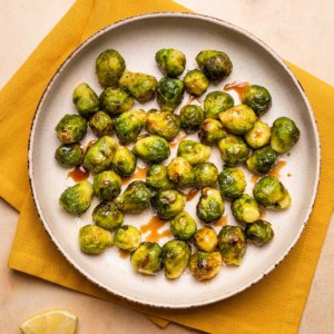 a plate of air fryer brussels sprouts with balsamic glaze drizzled over