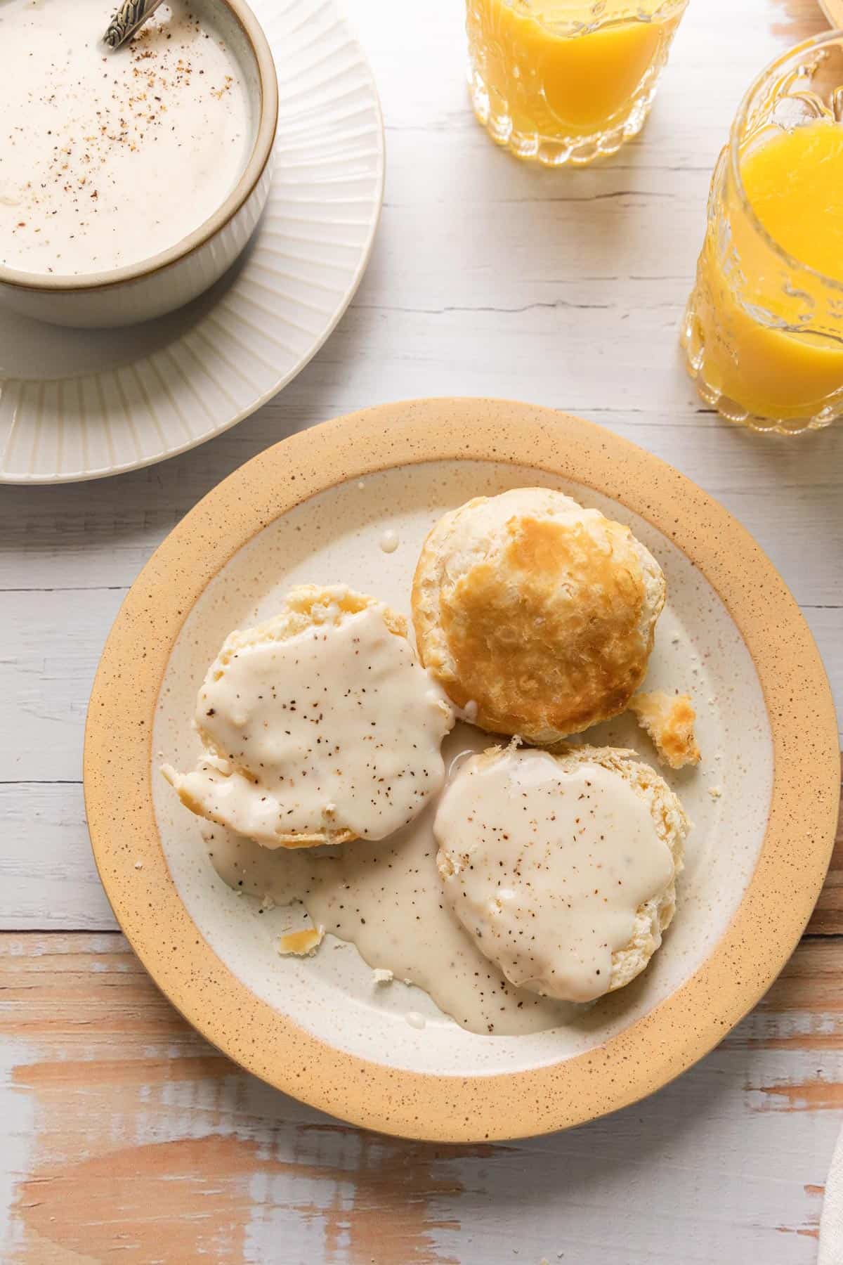 a plate of biscuits covered in bacon gravy for breakfast