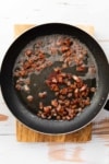 a skillet with chopped cooked bacon