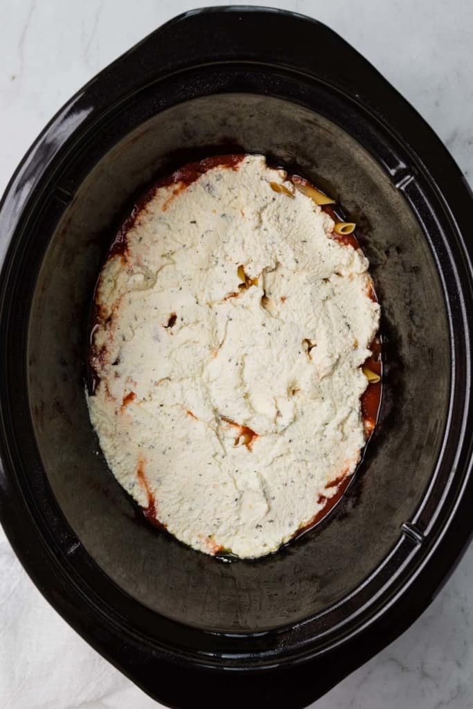 making a layer of ricotta cheese in a crockpot