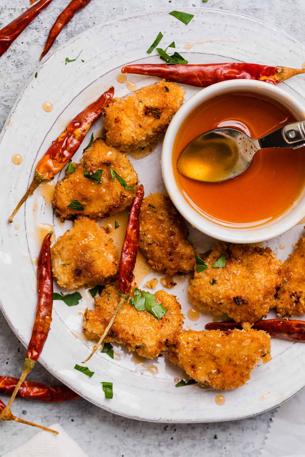 a plate of chicken nuggets with hot honey drizzled over