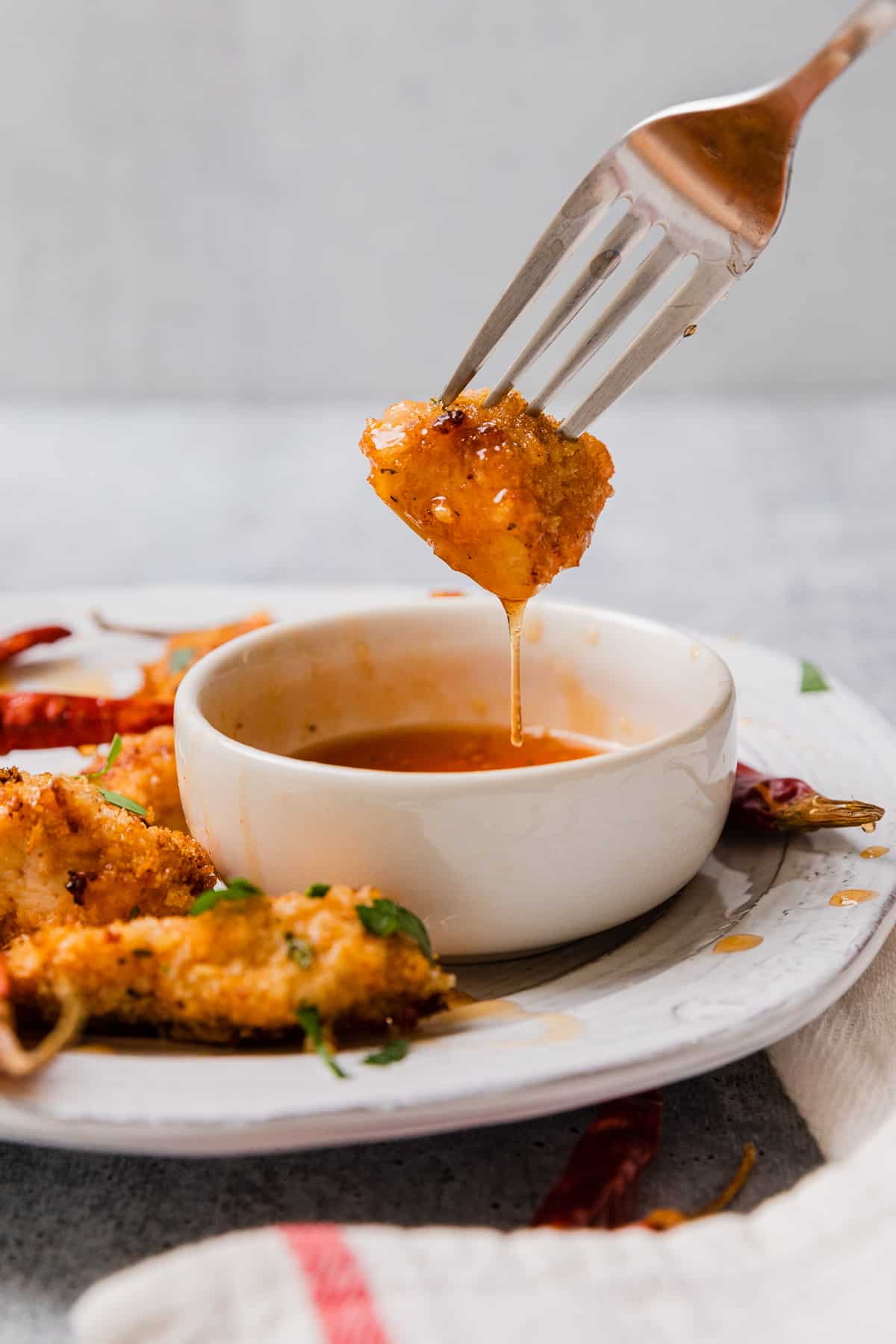 dipping a chicken nugget into a bowl of hot honey