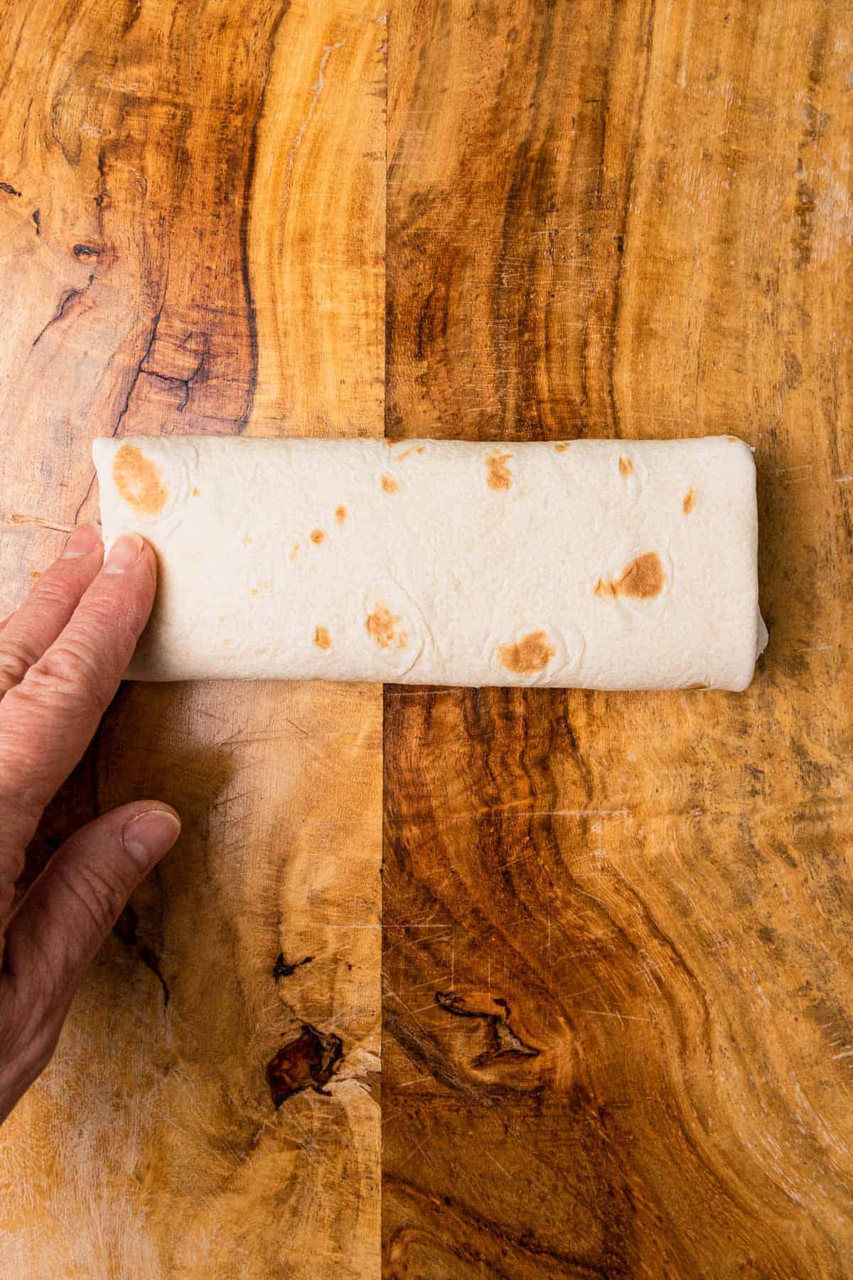 a finished burrito made with a flour tortilla
