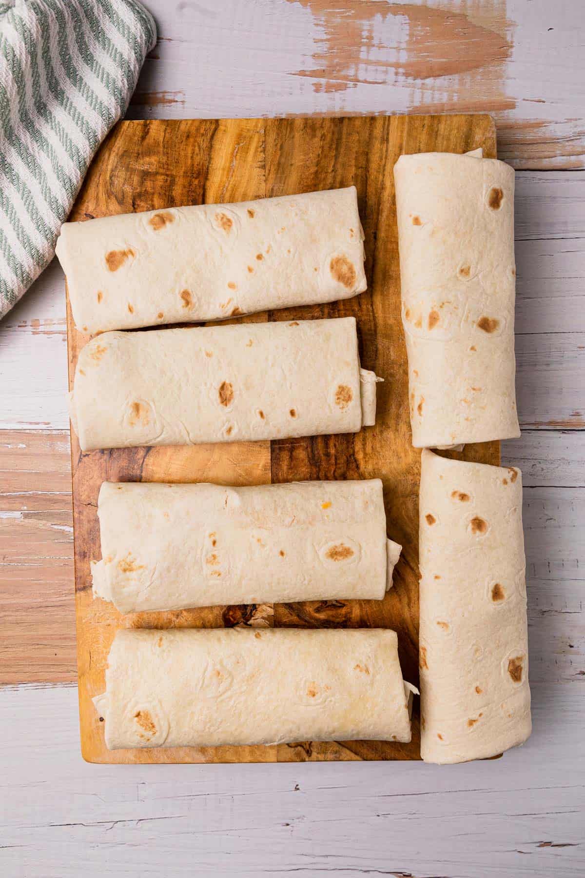 6 burritos on a cutting board