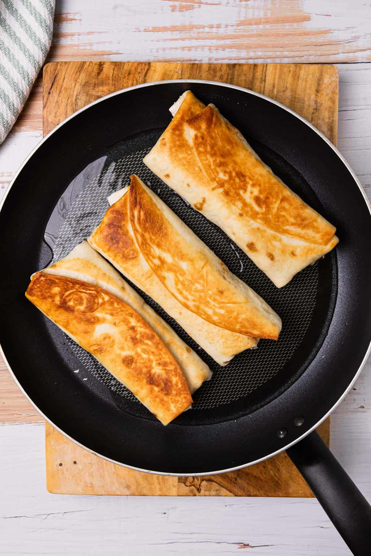 pan frying burritos in a skillet