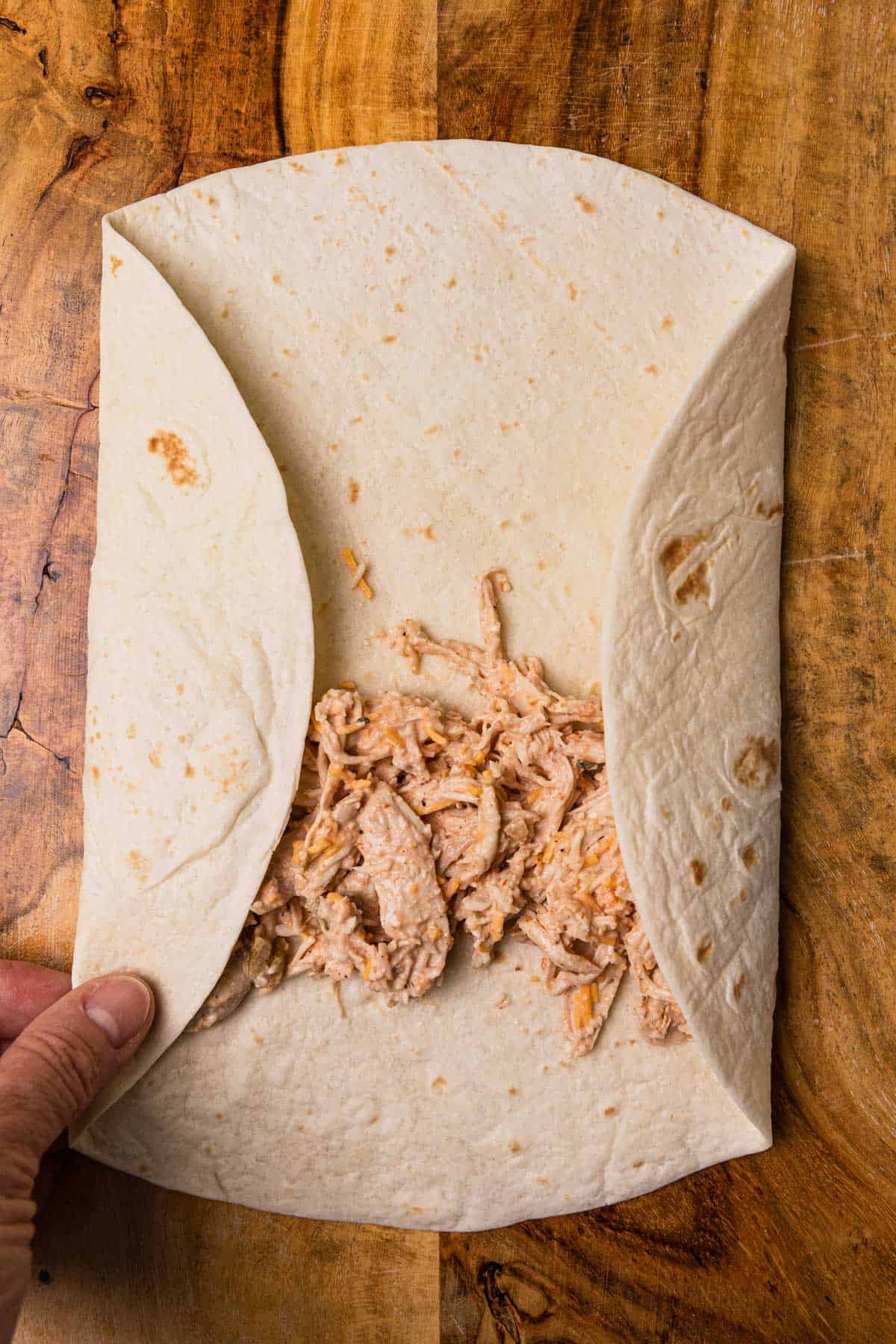 folding sides of tortilla to make a burrito