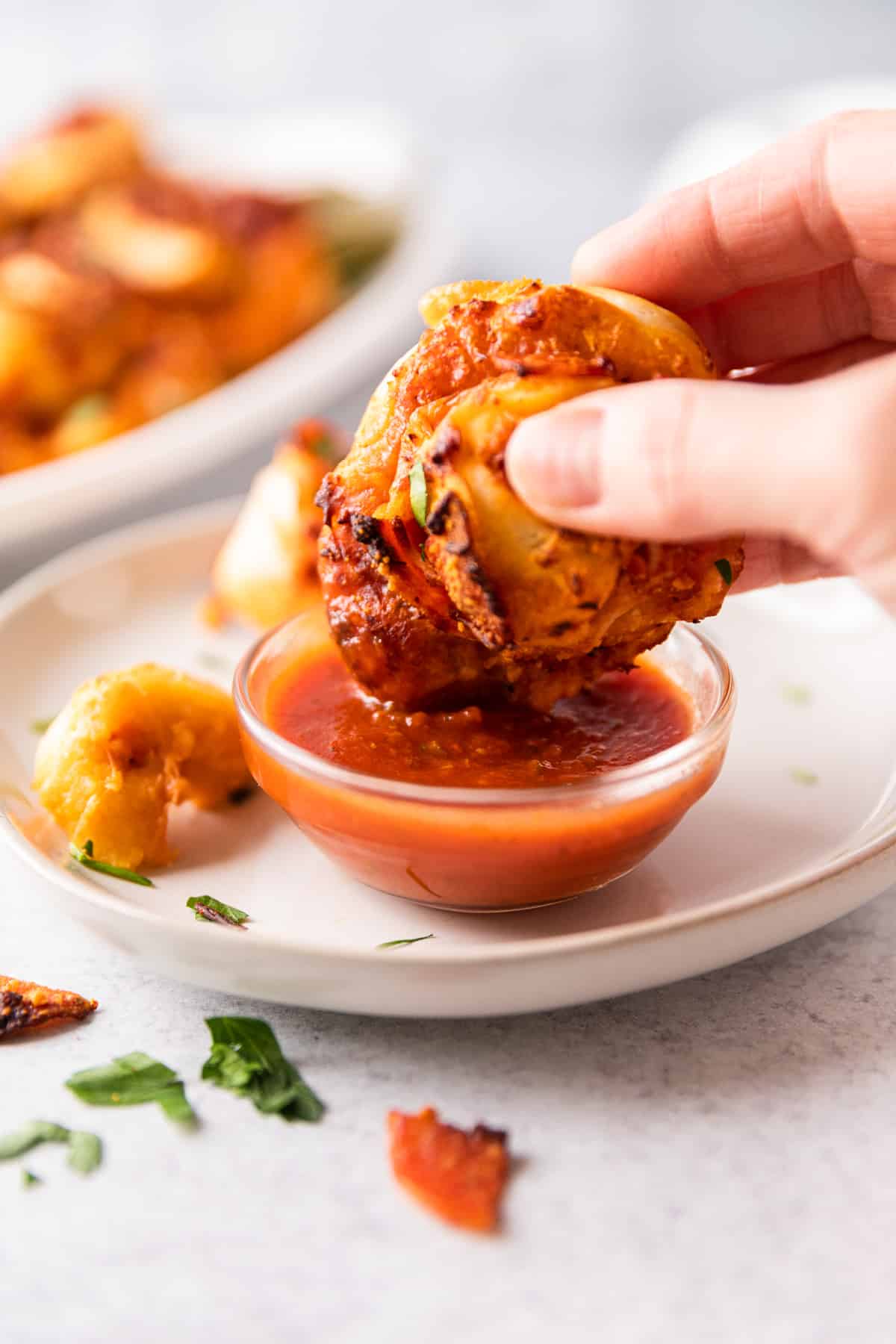 dipping a pizza roll into marinara sauce