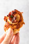 air fryer pizza roll held in a hand