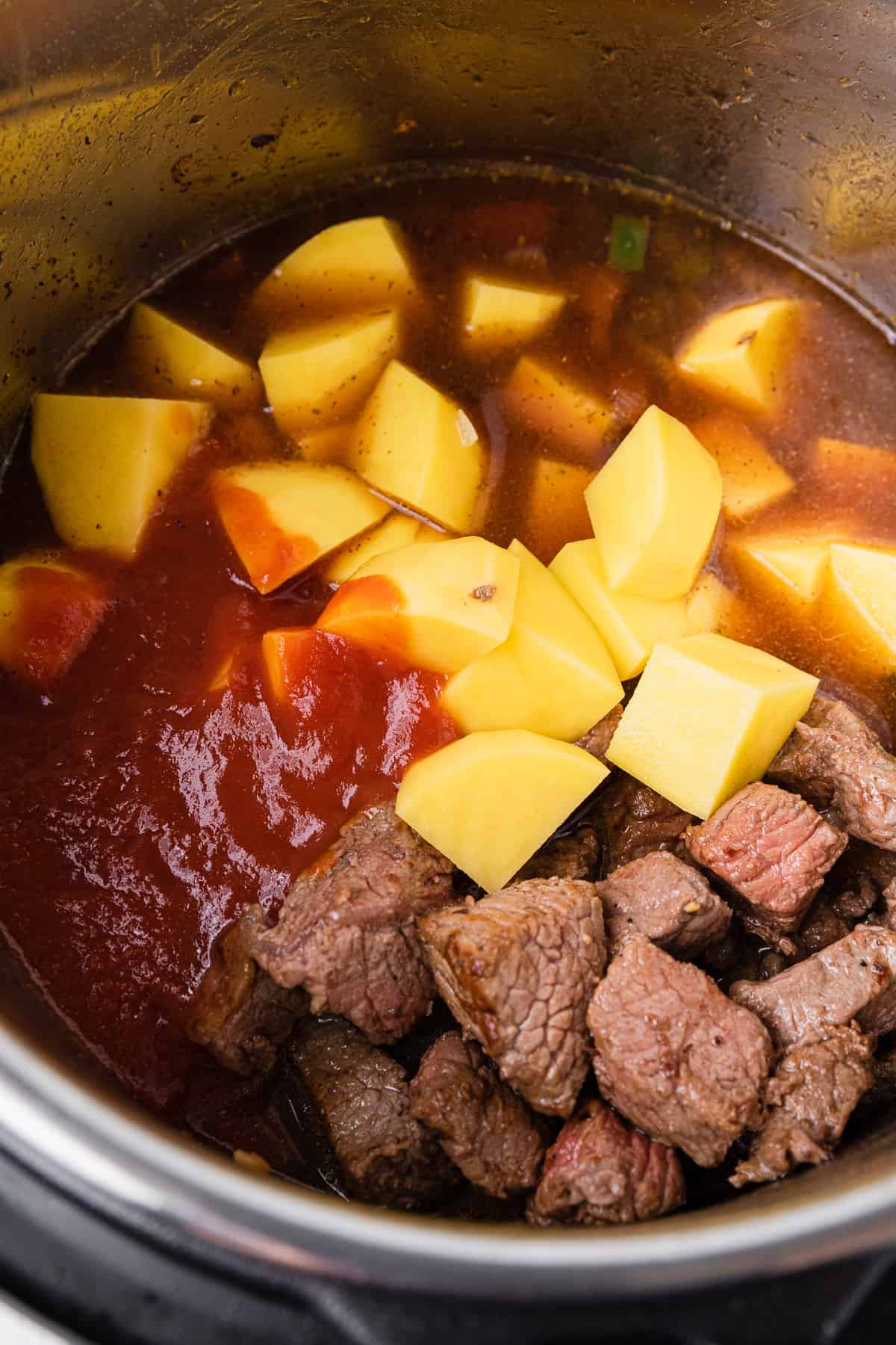 adding stew ingredients to the pot