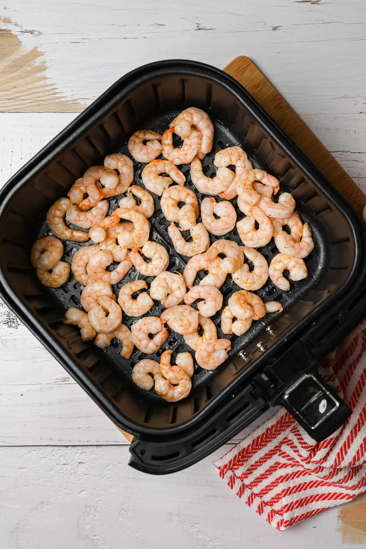 cooked shrimp in an air fryer basket
