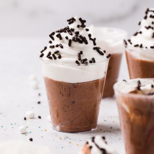 a hot chocolate pudding shot completed and topped with whipped cream